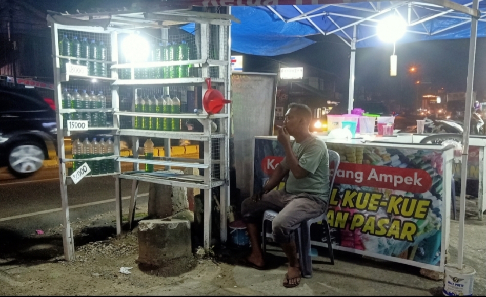 ANDI "Mak Itam" Gonzales, pedagang BBM eceran saat ditemui di warungnya di kawasan Simpang Tiga Bandar Buat di Jl. Indarung, Selasa (11/3). RYN