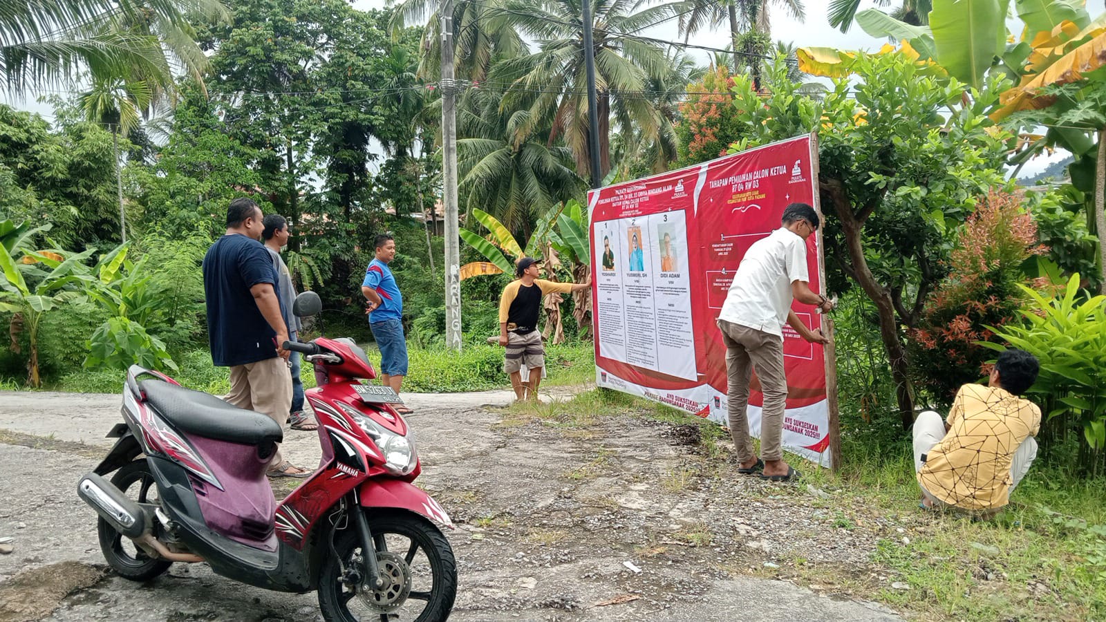 PANITIA Pilkate 04 RW 03 dibantu warga, tengah memasang alat peraga kampanye para calon Ketua RT.